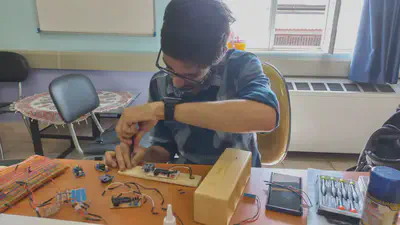 A cute picture of me assembling one of the boards inside one of the boxes